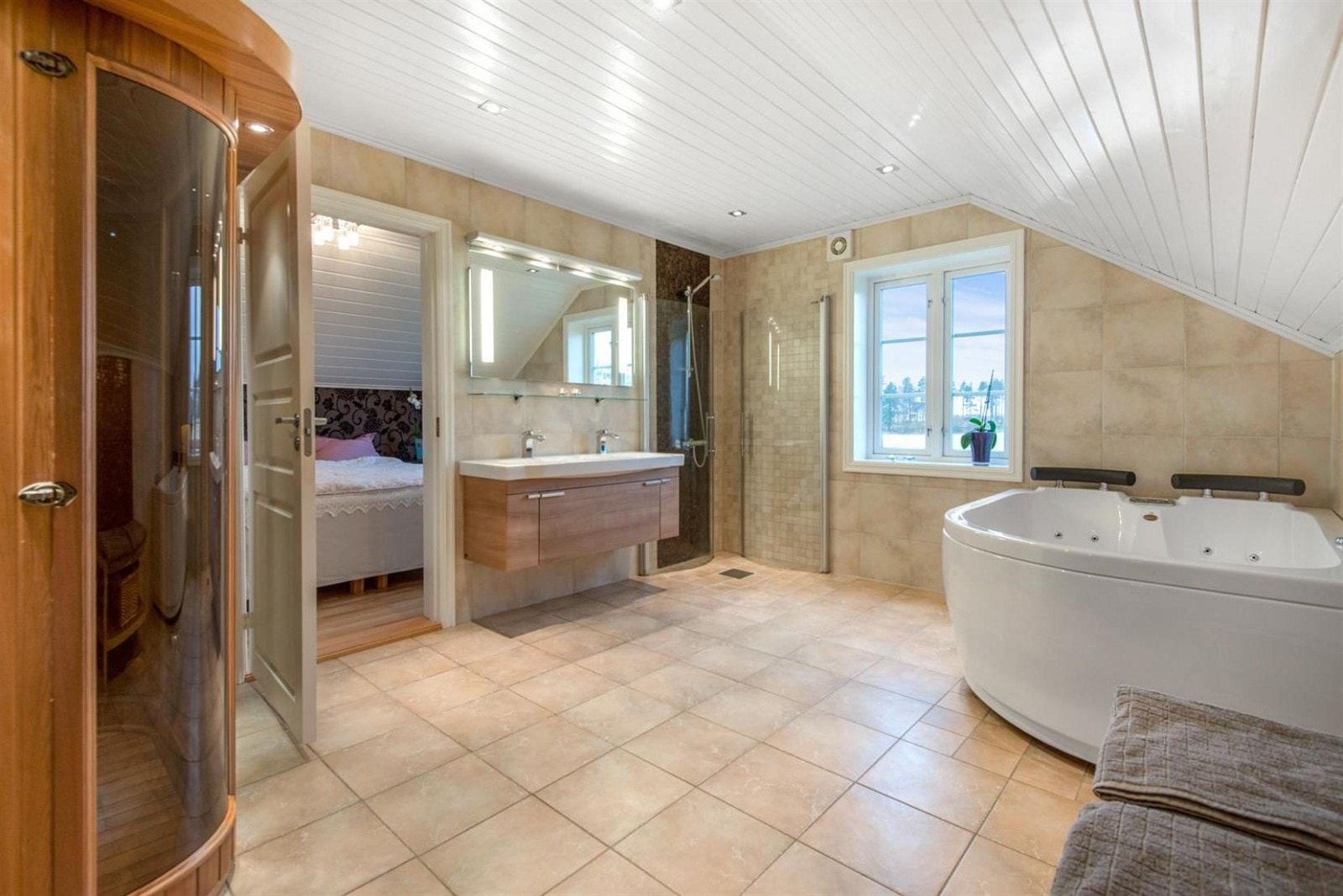Hovedbadet i andre etasje gir et delikat inntrykk med sandfargede gulv- og veggfliser, gulvvarme og downlights. Galleribilde