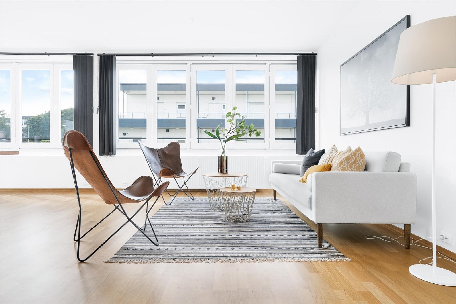 Dere trer inn i en stue med store vindusflater som gir et lyst og innbydende uttrykk i rommet. Galleribilde