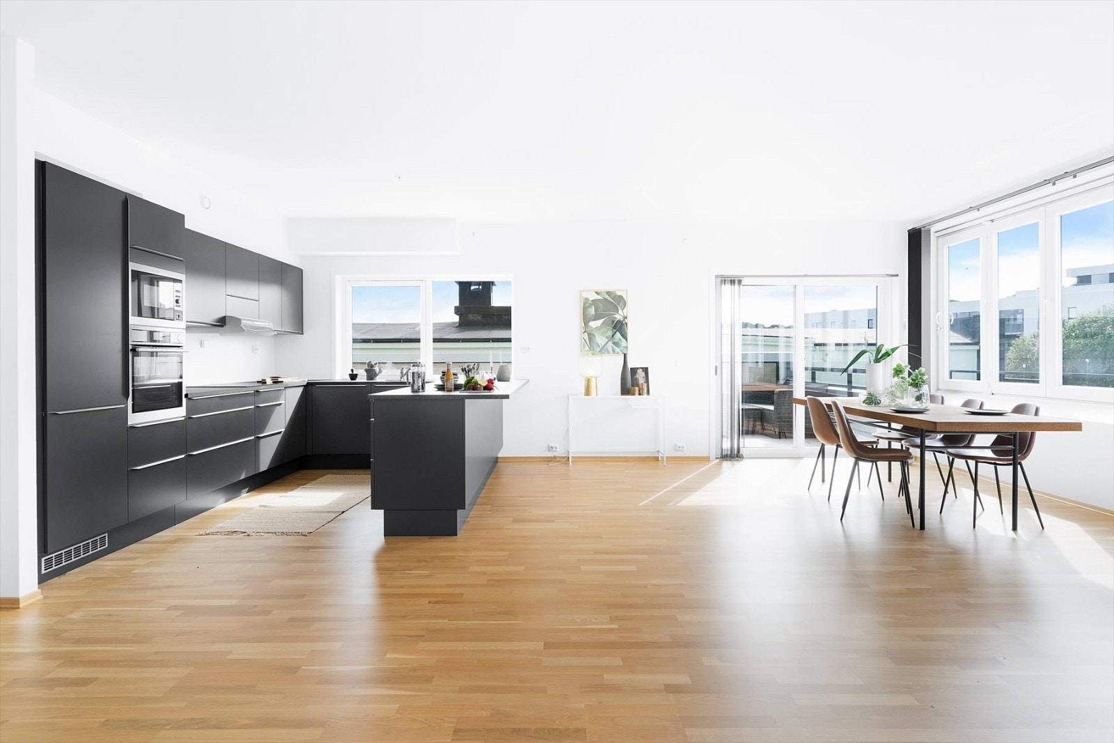 Den åpne løsningen mellom stue og kjøkken bevarer en fin romfølelse og god kontakt mellom kokk og gjester. Det er imidlertid enkelt å sette opp en vegg, som kan skille stue/kjøkken om det er ønskelig. Galleribilde