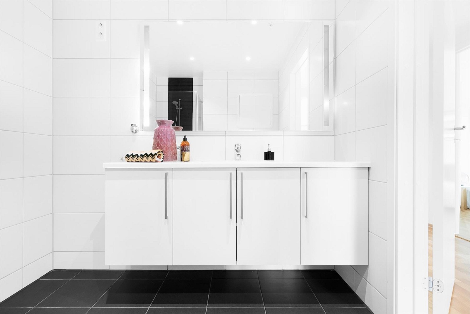 Hvite baderomsmøbler fra HTH - som er en merkevare kjent for sin moderne design, funksjonalitet og fremtredende kvalitet. Speil med integrert lys og spotter i tak. Galleribilde