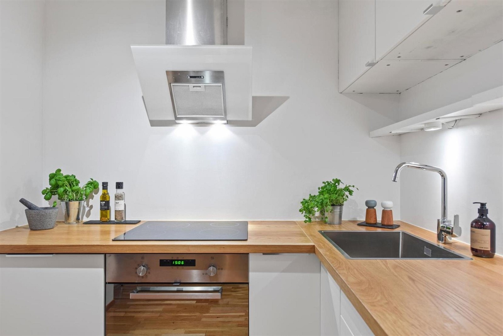 Kjøkkenet er innredet med hvite glatte fronter og benkeplater i eik. Galleribilde