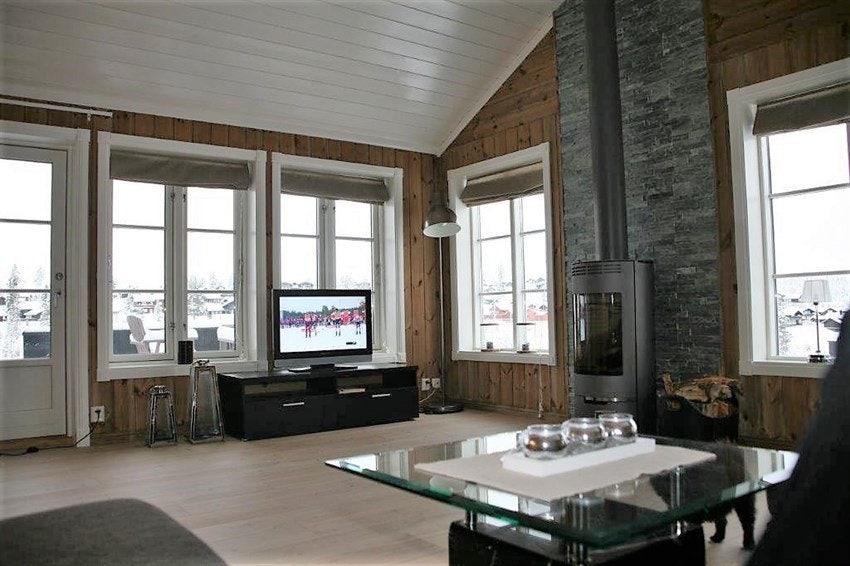 Pen stue med store lysflater og utgang til terrasse. Galleribilde