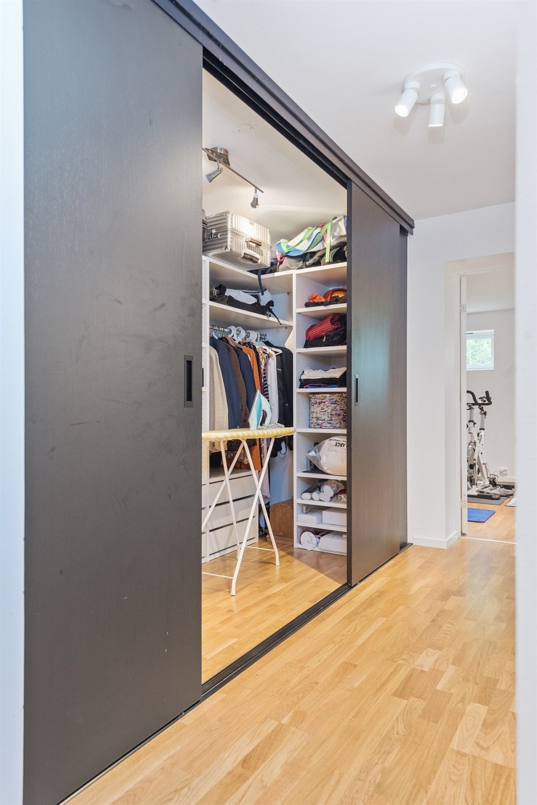 PROA Eiendomsmegling - Mellom gang og trimrom i kjeller er det et rom som er innredet som et oppbevaringsrom med en større garderobeinnredning. Galleribilde