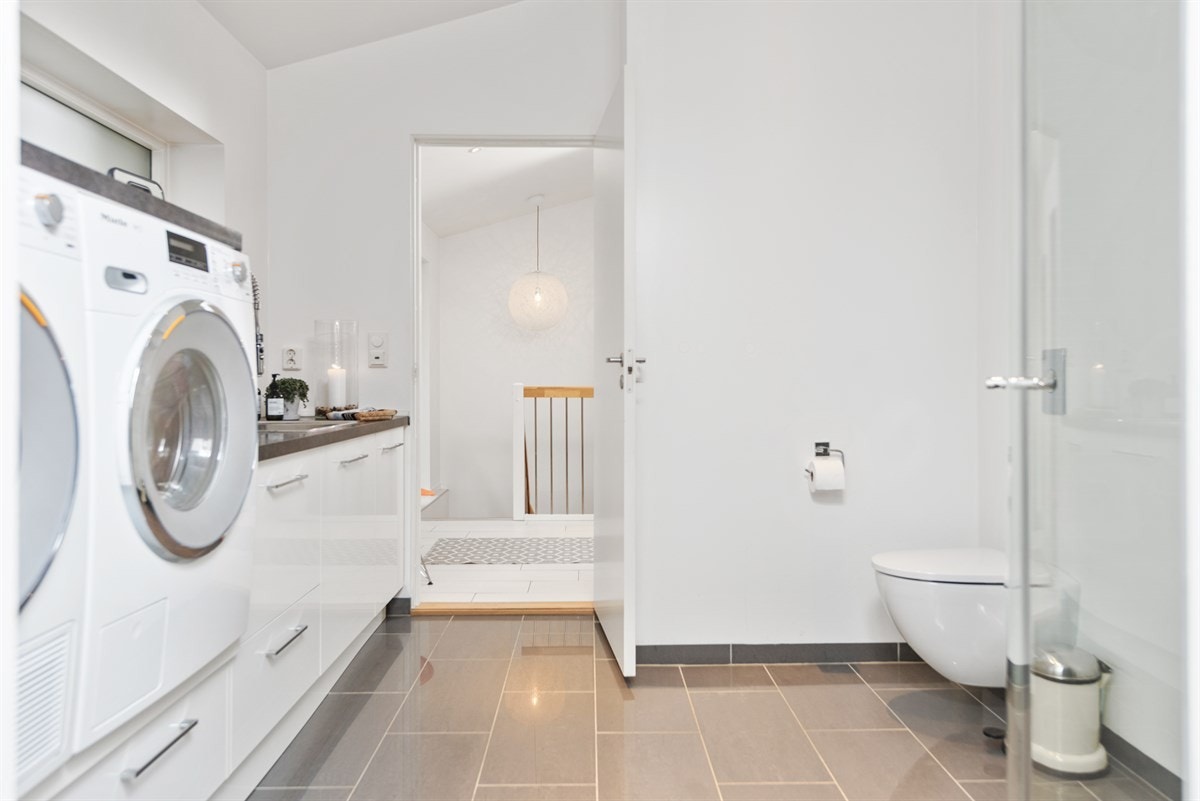 PROA Eiendomsmegling - Lyst bad- og vaskerom med flott innredning med mye skap- og benkeplass. Galleribilde