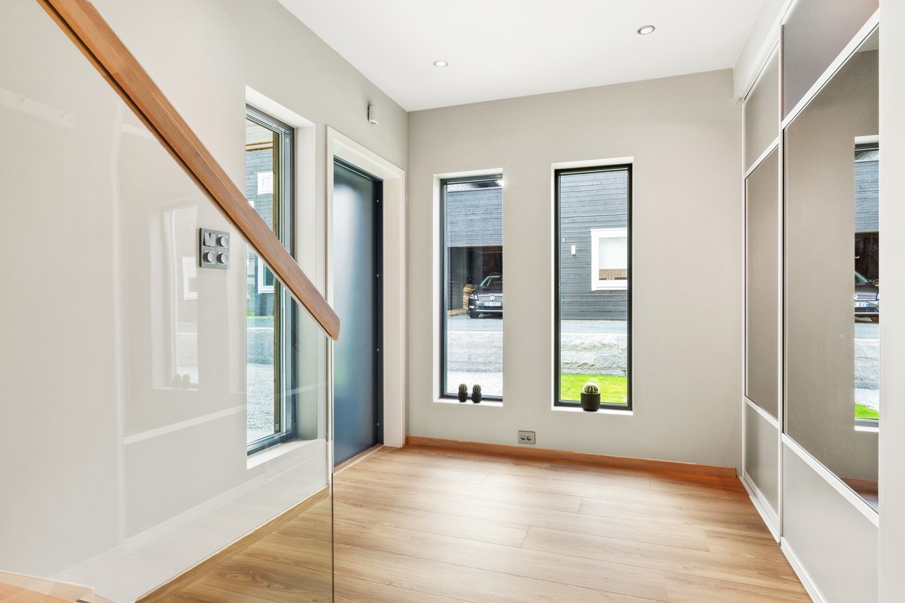 Nede i 1.etg starter vi med entre'en som ønsker deg velkommen inn i boligen er romslig, og har integrert skyvedørsgarderobe med speil Galleribilde