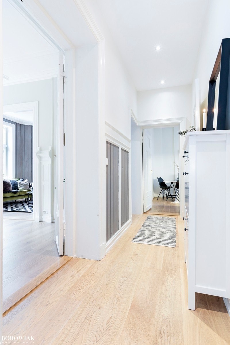 Allerede i entréen opplever en hvor elegant og stilsikker boligen er, med eksklusive materialvalg som hvitlasert eikeparkett og utstrakt bruk av innfelt downlights Galleribilde