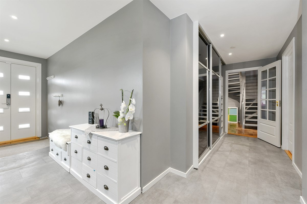 Entreen gir et godt førsteinntrykk av eneboligen og er utstyrt med bl.a. romslig skyvedørsgarderobe, laminat på gulv, alarmpanel og innfelt punktbelysning i tak. Galleribilde