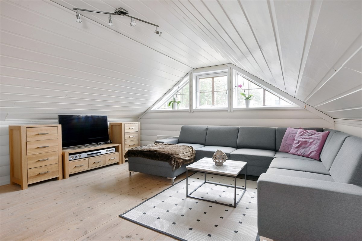 Loftetasjen har en koselig loftstue med god plass for sofamøblement og tilhørende og tv-løsning, noe som gir ekstra spillerom og privatliv for barnefamilier. Galleribilde