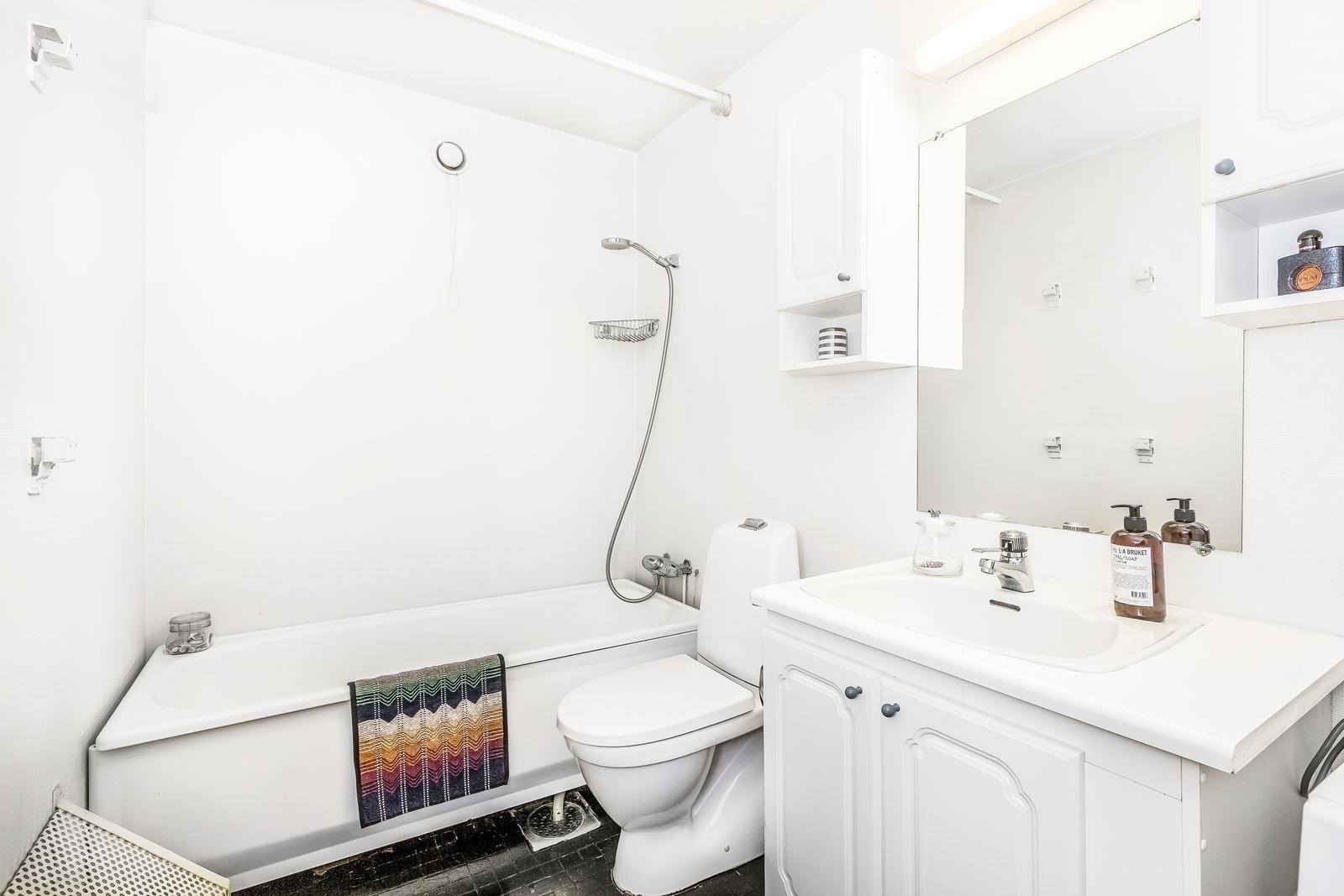 Badet består av servant med underskap, badekar, gulvmontert toalett og helstøpt servant med ett-greps blandebatteri. Det er opplegg for vaskemaskin. Galleribilde