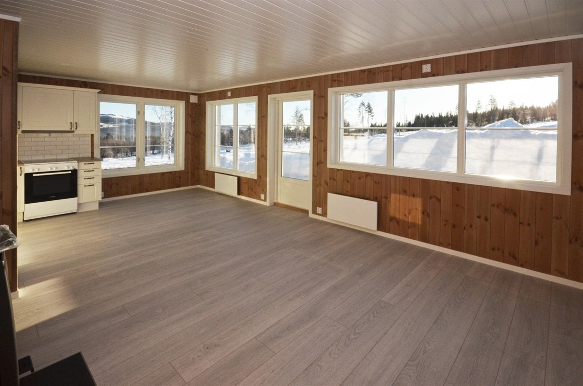 Stor, lys og åpen stue med peisovn og utgang til terrasse. Galleribilde