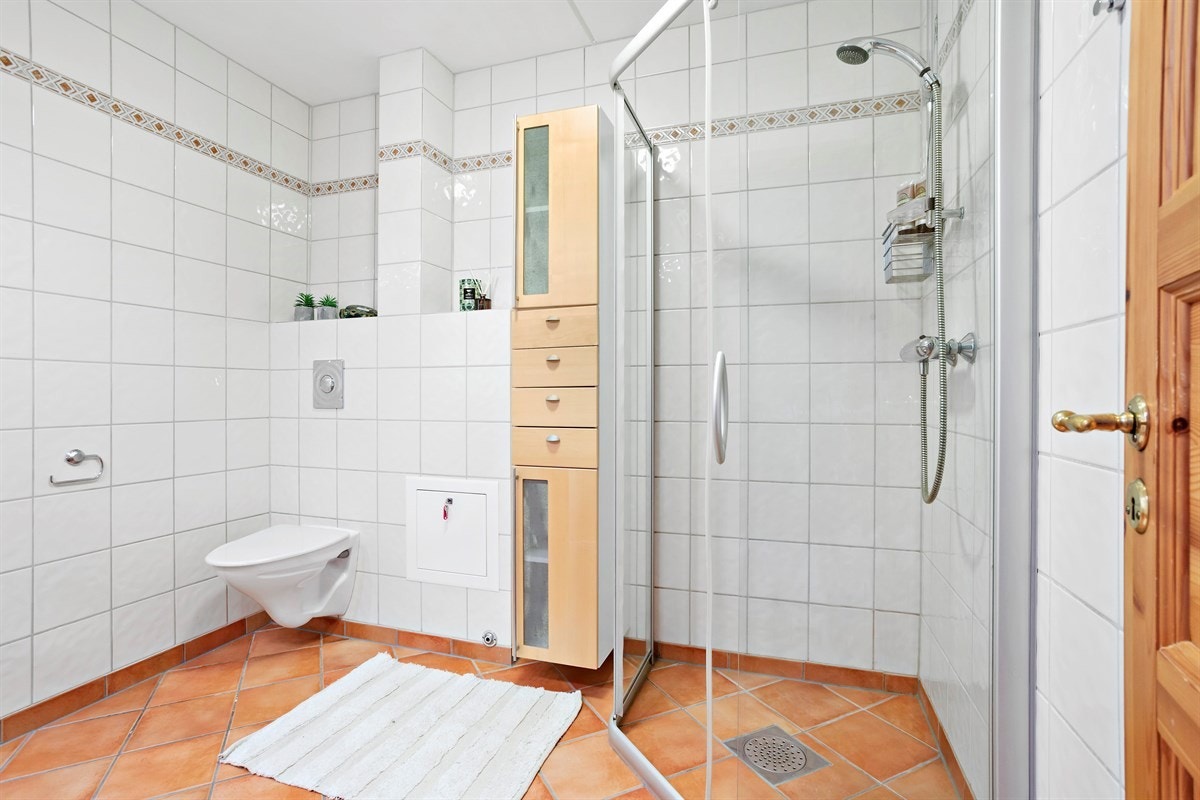 Romslig bad med fliser på gulv og vegger, samt gulvvarme. Galleribilde