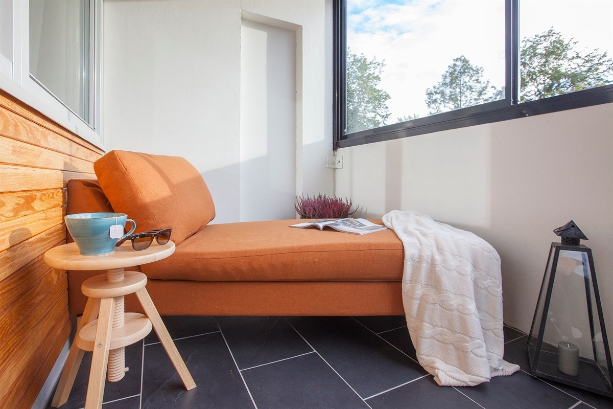 Den innglassede balkongen utgjør et ekstra oppholdsrom på varme sommerdager Galleribilde