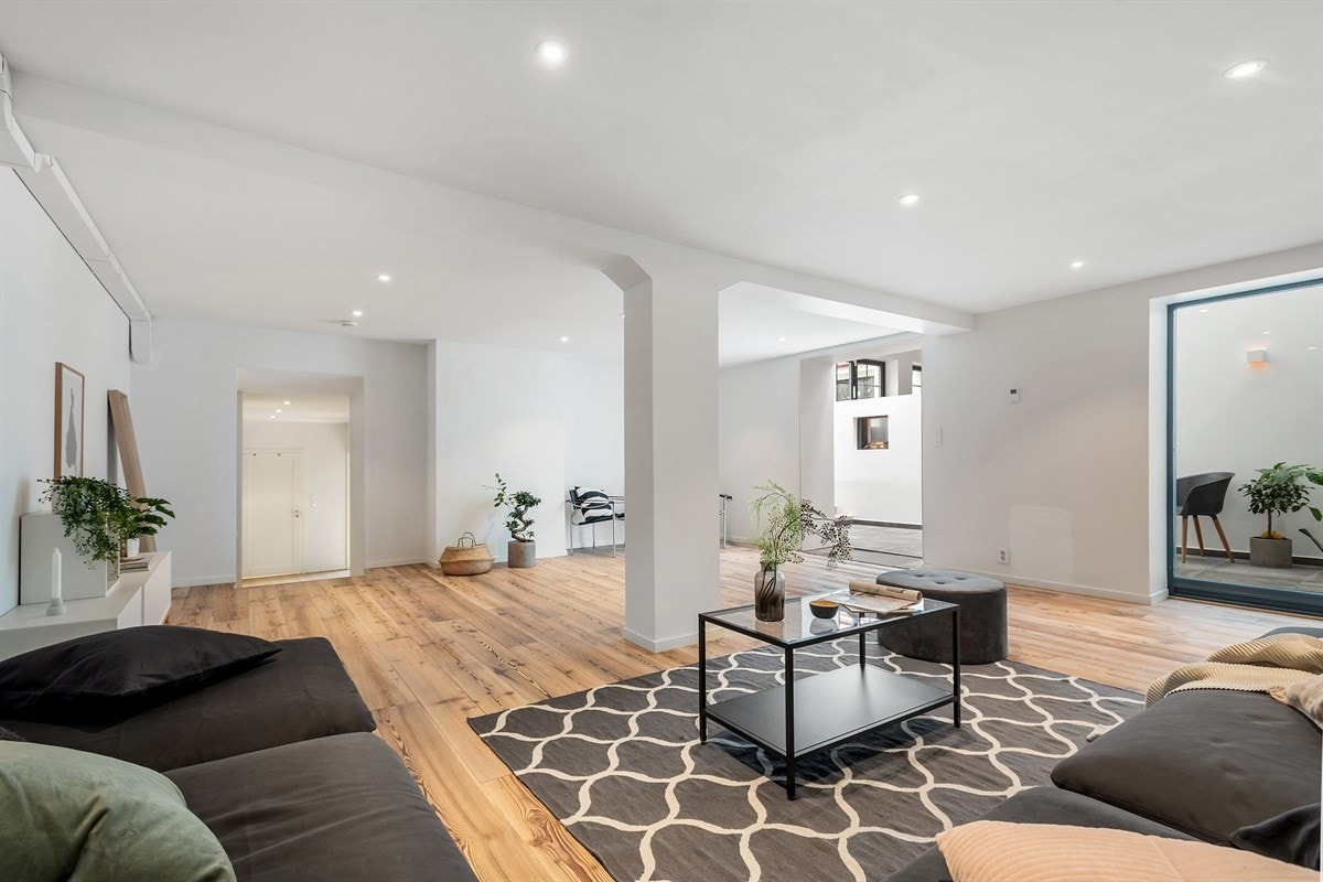 Stor kjellerstue hvor det er plass til flere sittegrupper Galleribilde