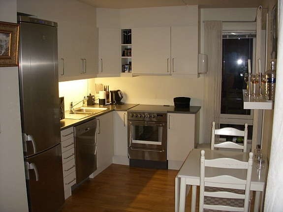 Kjøkken med kjøl/frys, oppvaskamaskin og komfyr. Galleribilde