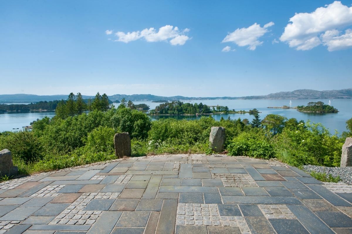 I front av boligen er det en stor steinbelagt uteplass med fri utsikt. Galleribilde
