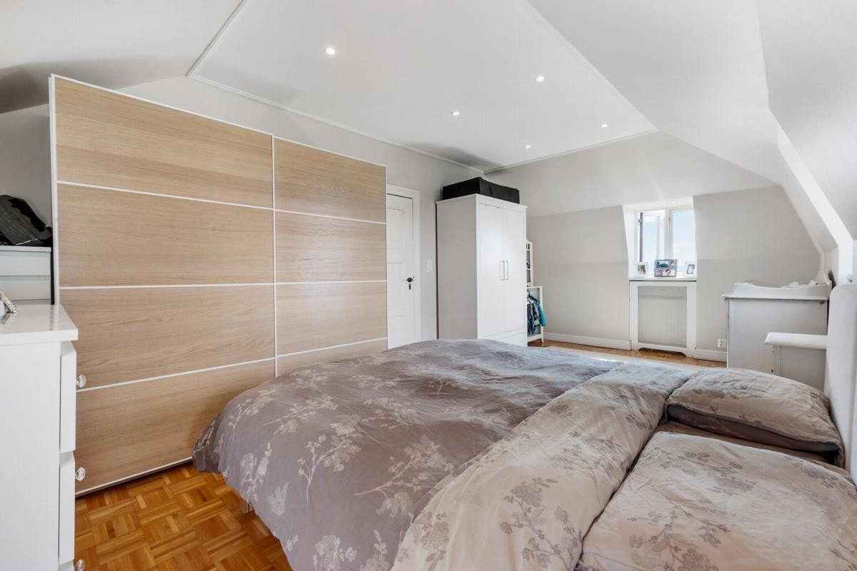 Lyst og lekkert soverom med integrert belysning og stort garderobeskap. Galleribilde