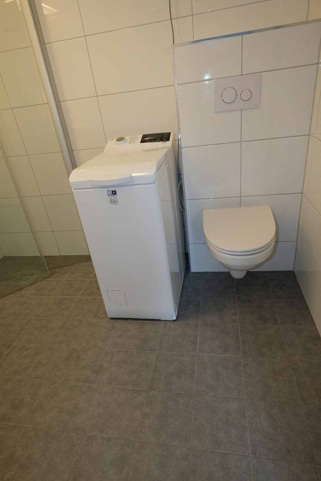 På bad: Dusjhjørne, servant, speil-overskap, vaskemaskin og toalett Galleribilde