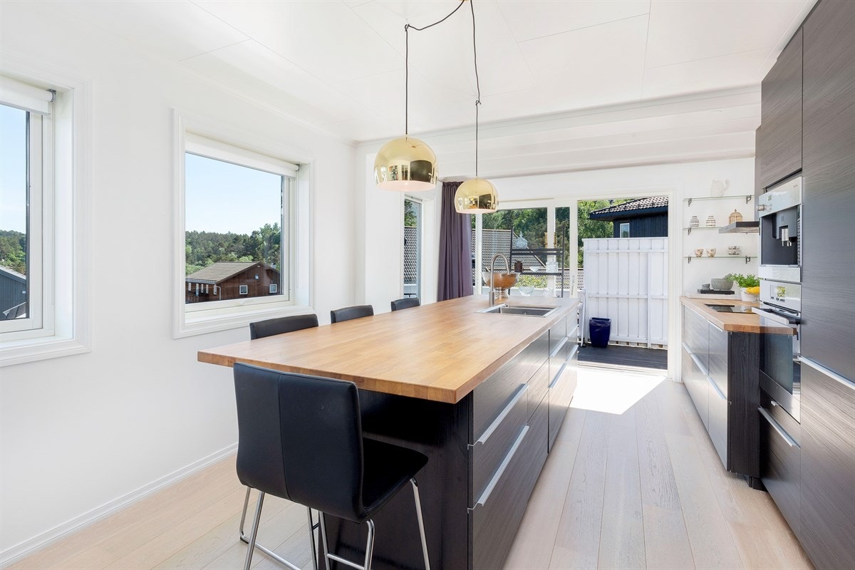 Flott påbygd kjøkken i 2015 med eik plank på gulv, integrerte hvitevarer og stor kjøkkenøy Galleribilde