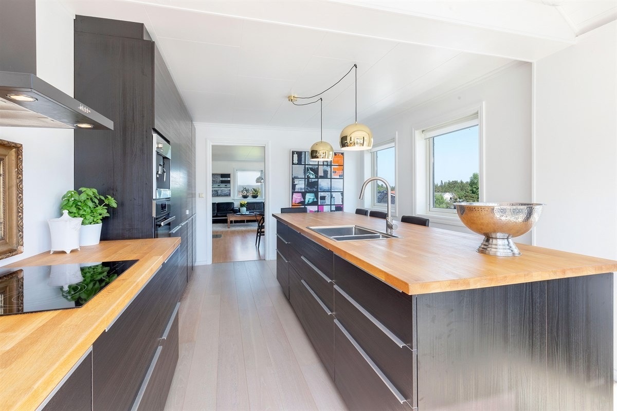 Flott påbygd kjøkken i 2015 med eik plank på gulv, integrerte hvitevarer og stor kjøkkenøy Galleribilde