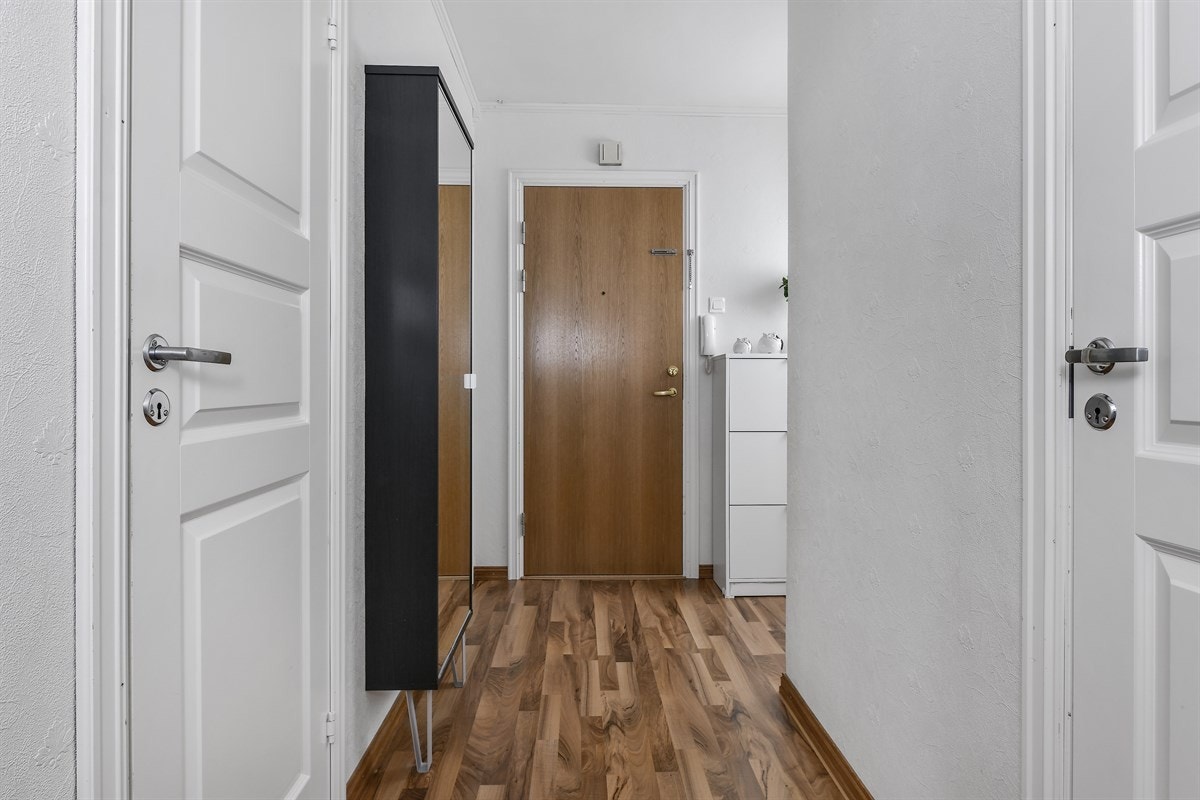 Entreen er romslig, lys og innbydende med laminat på gulv og hvitmalte vegger. Galleribilde