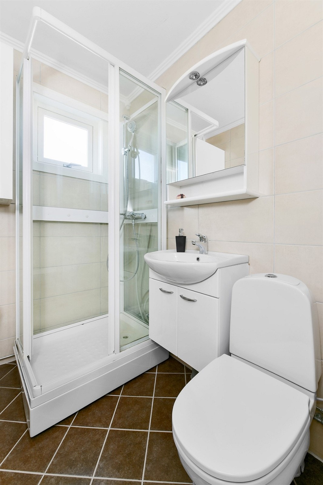 Et lite vindu gir innslipp av naturlig lys til rommet. Videre har badet mekanisk avtrekk, speilskap med overlys, enkel servant på hvitt servantskap, og veggskap. Galleribilde