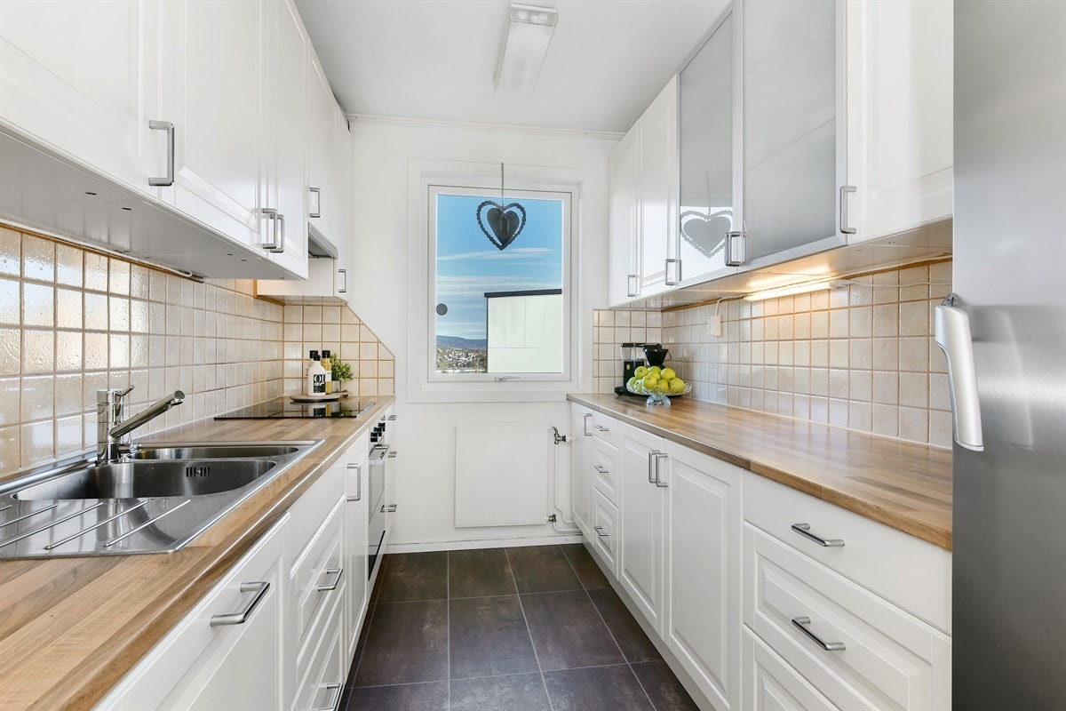 Leiligheten har et lyst og velutstyrt kjøkken med god benke- og lagringsplass i moderne, takhøy Ikea-innredningen, samt fin utsikt fra kjøkkenvindu. Galleribilde