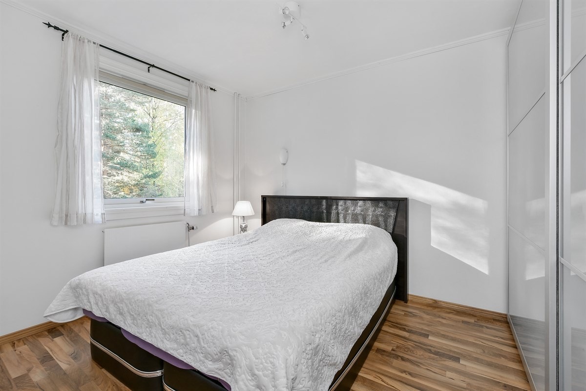 Leiligheten har to lyse og gode soverom med laminatgulv og hvitmalte vegger, begge med sydvendte vinduer mot skogen. Galleribilde