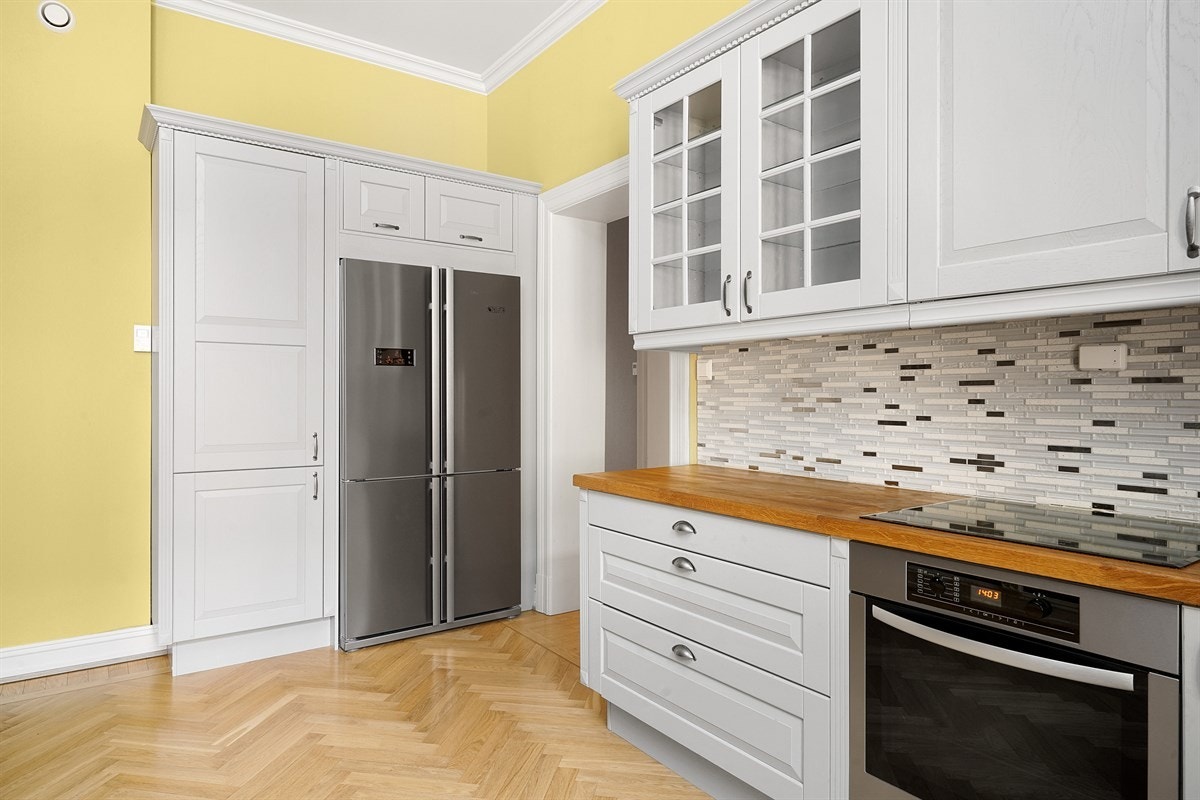 Leilighet 1. etasje. Innredningen har grå, profilerte fronter, to vitrineskap, pent listverk med sukkerbiter og benkeplate i heltre med vaskekum i kompositt. Kjøkkenet har integrert stekeovn, keramisk koketopp og oppvaskmaskin. Galleribilde