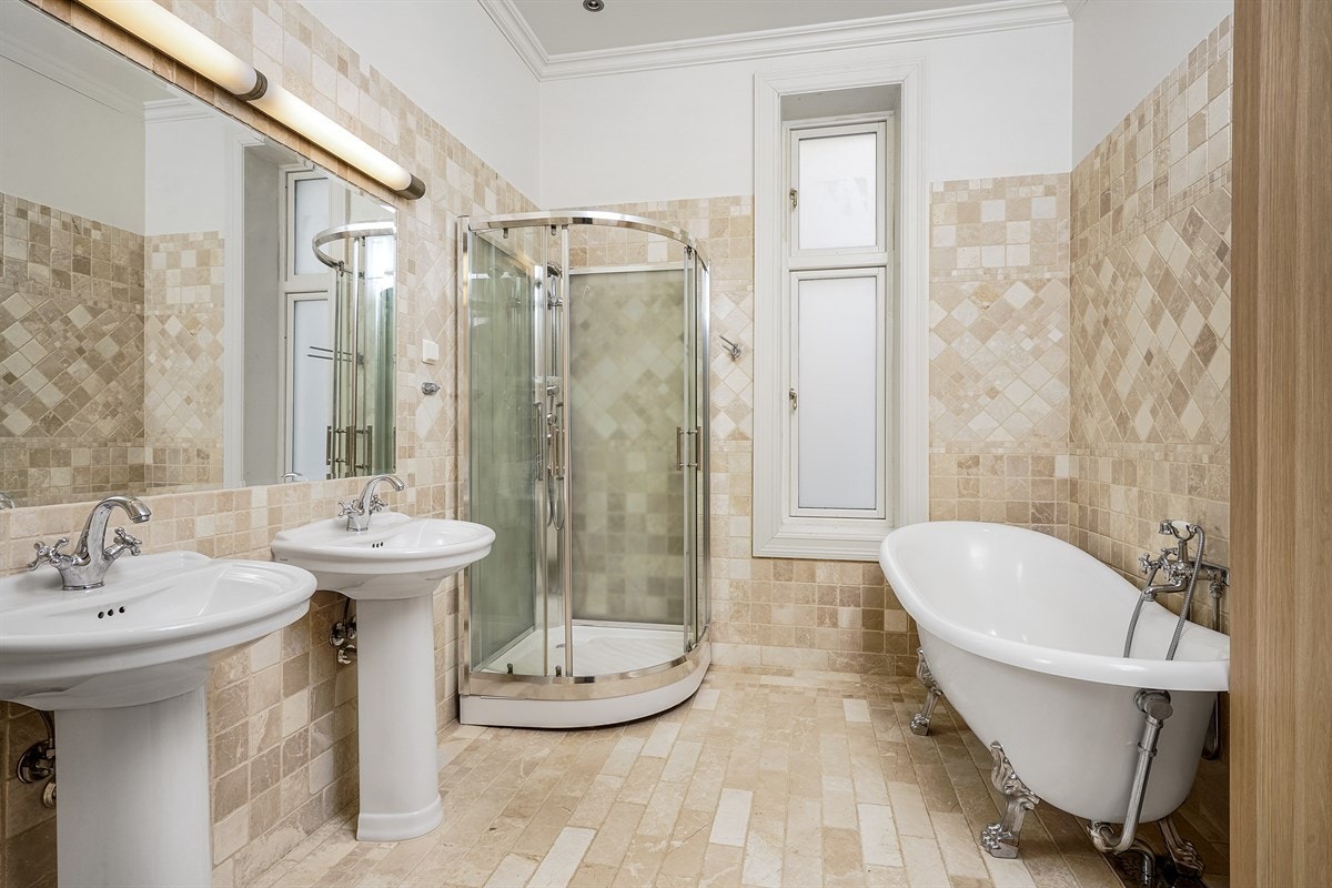 Leilighet 1. etasje. Leiligheten har et bad og et dusjbad. Badet har lyse gulvfliser og fliser på vegg opp til normal takhøyde. Galleribilde