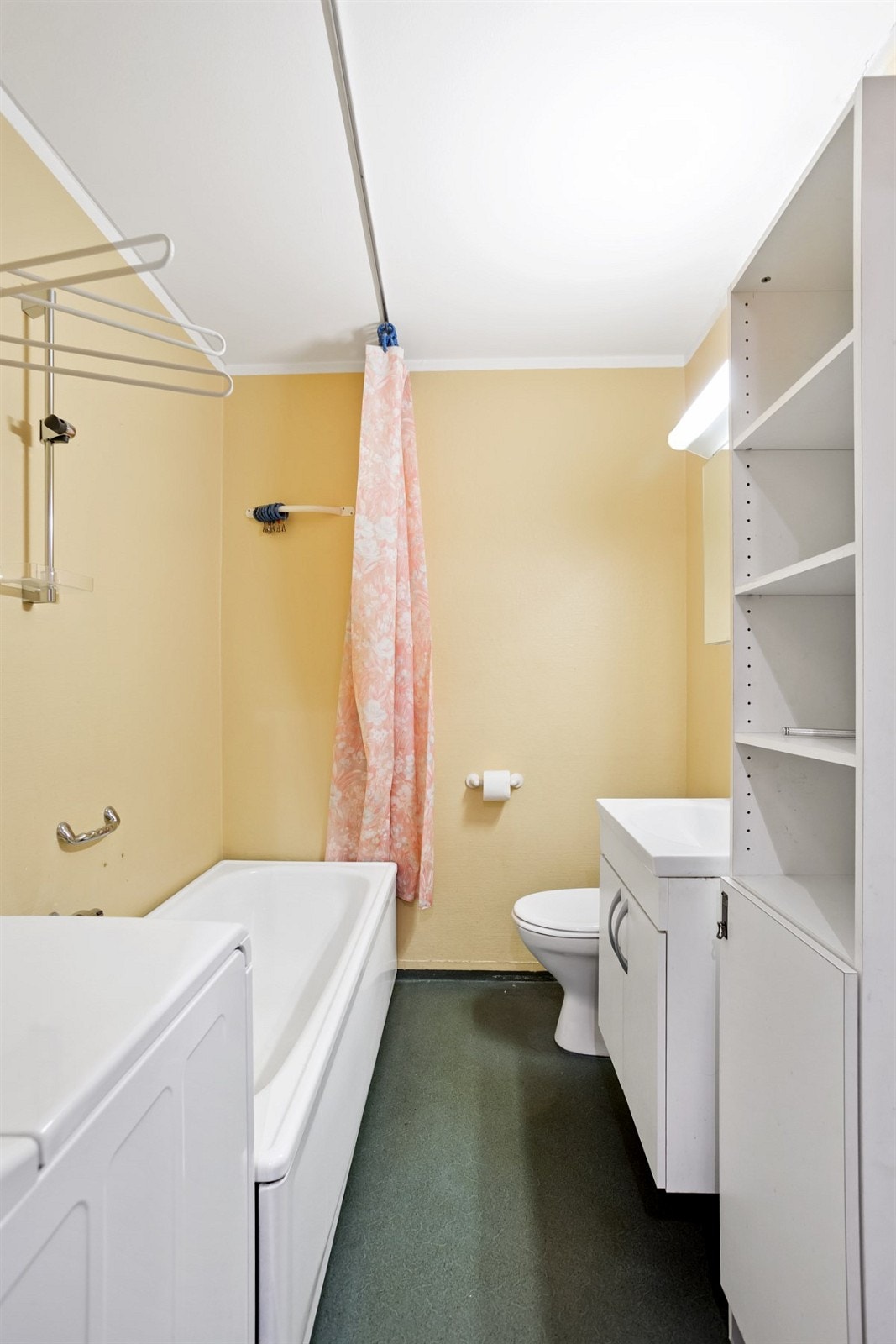 Baderom med klosett, badekar, servant og opplegg for vaskemaskin. Fellesvaskeri i borettslaget Galleribilde