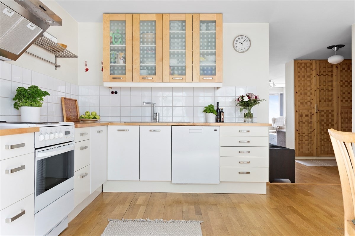 Kjøkkeninnredning fra IKEA med hvite fronter og bjerkefronter, 1,5 oppvaskkum, fliser mellom overskap og heltre benkeplate. Galleribilde