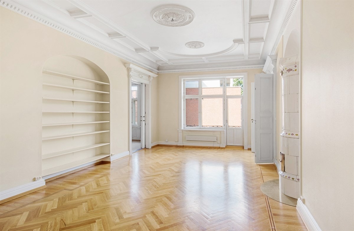 Leiligheten har tre store stuer, alle med takhøye vinduer, dype vinduskarmer, ekstra takhøyde, nydelige rosetter og intrikat stukkatur. Galleribilde