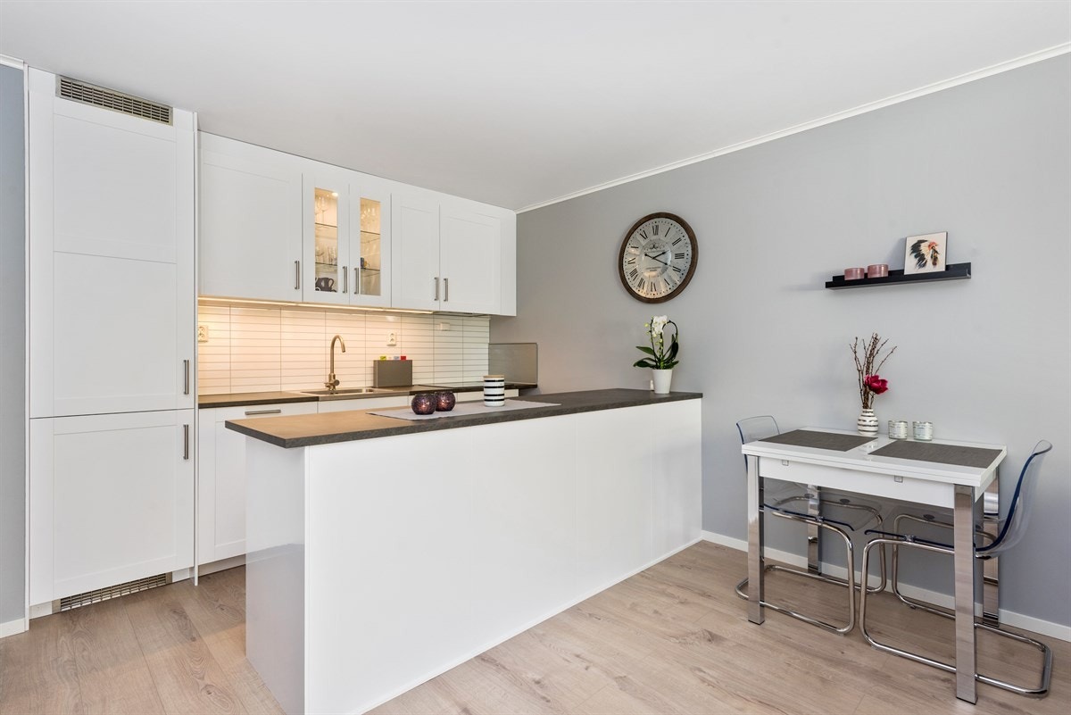 Åpen kjøkkenløsning med nyere hvitevarer og gjennomførte løsninger Galleribilde