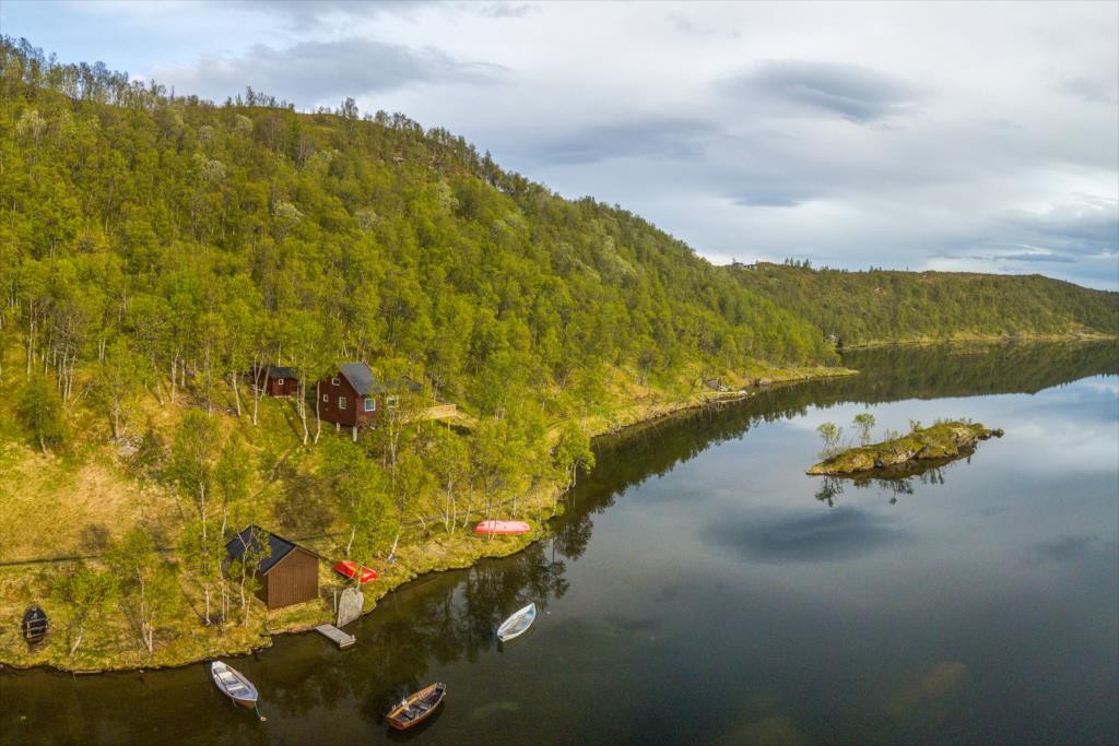 naustet i forgrunnen med hytta likke ovenfor Galleribilde