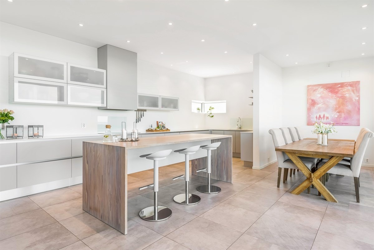 En stor kjøkkenøy gir sitteplasser for barna som gjør lekser eller venner som tar seg ett glass mens vertskapet lager middag. Galleribilde