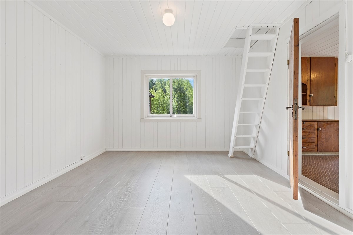 Fra soverommet går det åpen, hvitmalt trapp opp til loft. Galleribilde