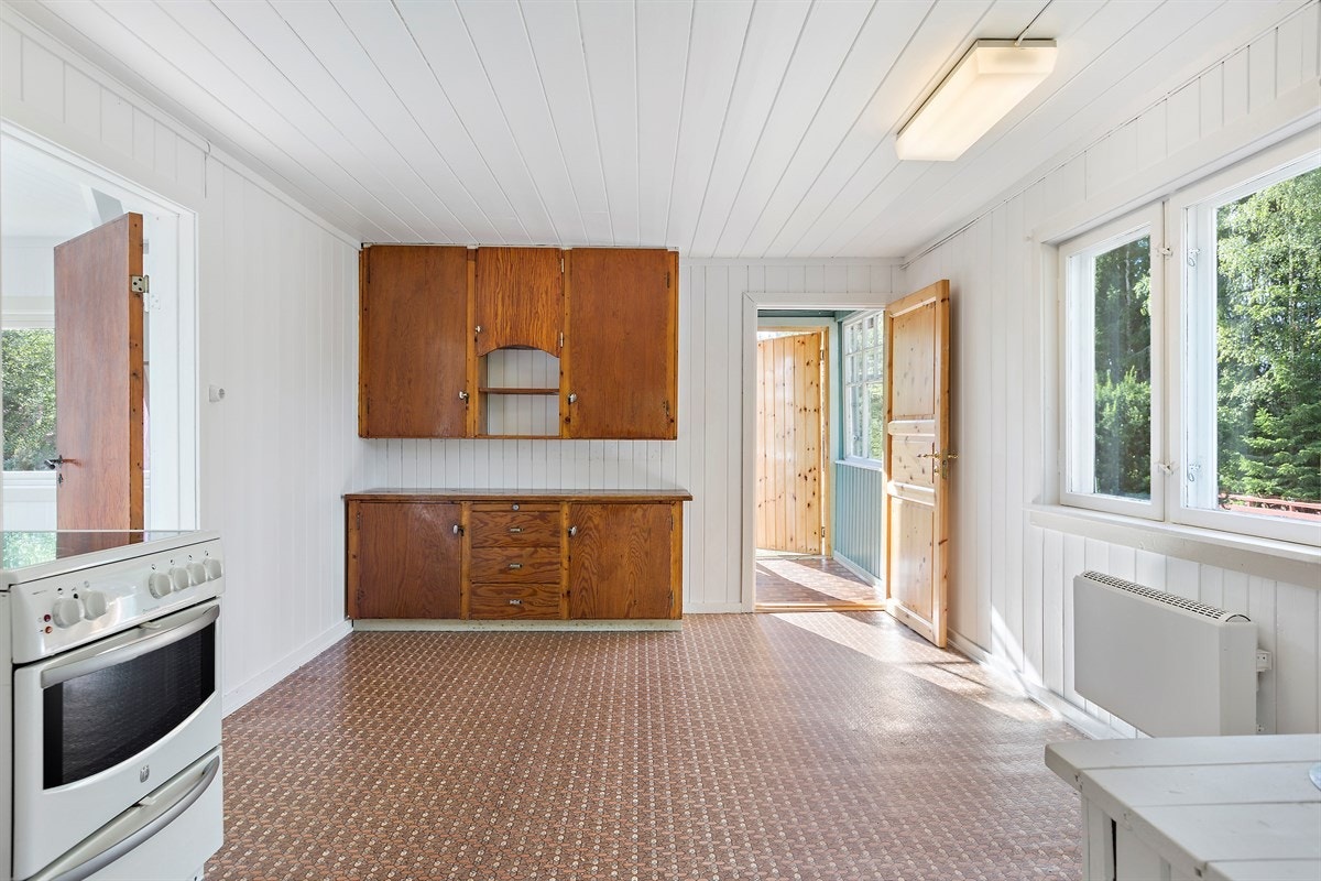 Kjøkkenet ligger i eget rom med vedovn og plass for et trivelig frokostbord under vinduet. Galleribilde