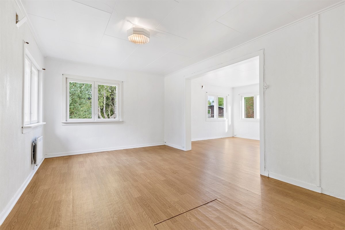 Det er åpen gjennomgang mellom stuene og med vinduer på tre sider får rommen et fint gjennomlys. Galleribilde