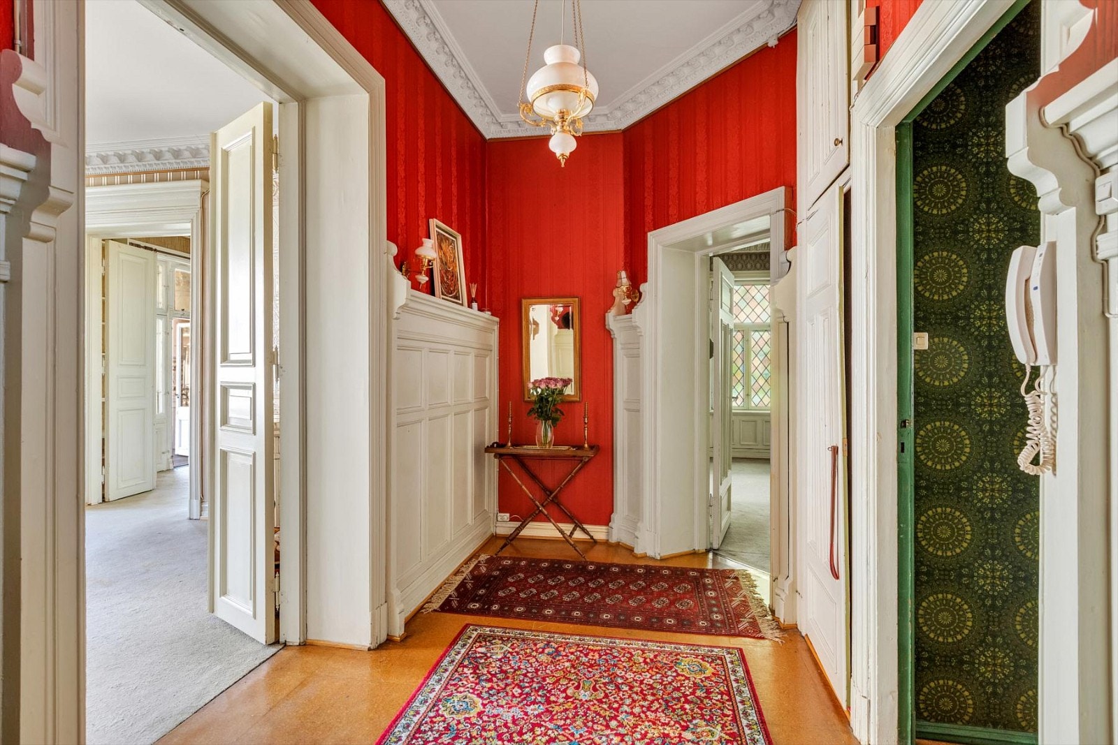 En lys og pen entré med dobbel dør inn til hovedstuen og spisestuen. Enkel dør inn til mellomgangen til kjøkkenet Galleribilde