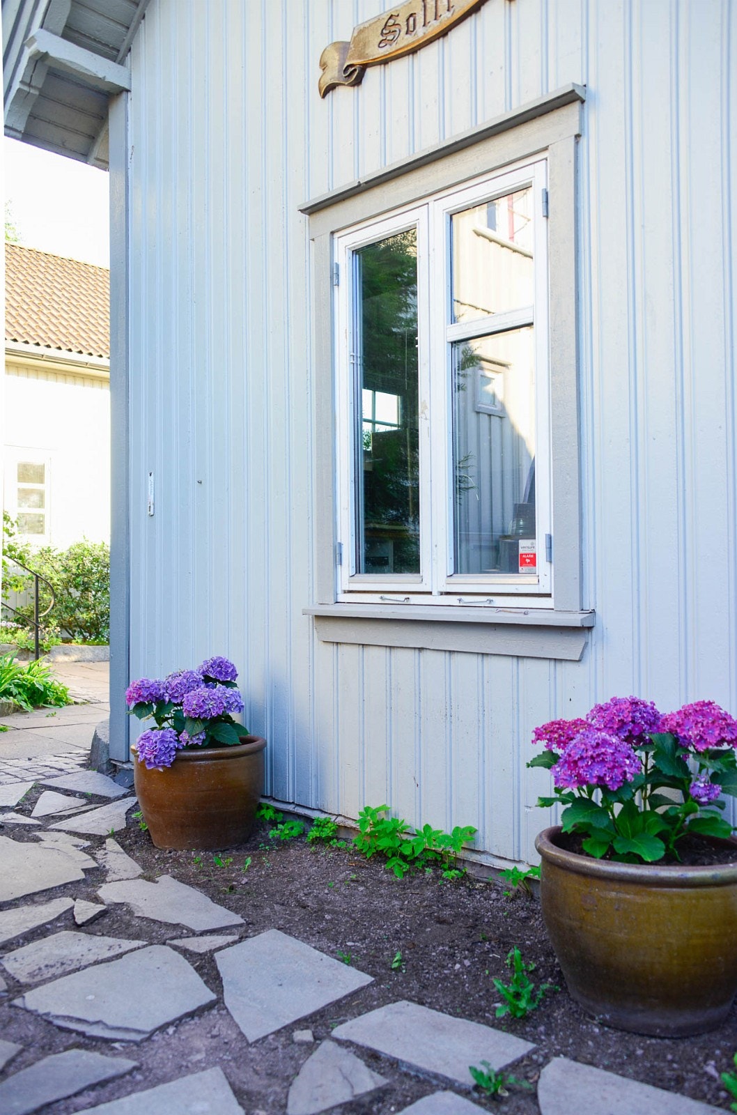 Foran annekset er det satt opp et par blomsterkrukker med roser (tidligere Hortensia) for å gjøre inngangspartiet inn til huset litt triveligere. Galleribilde