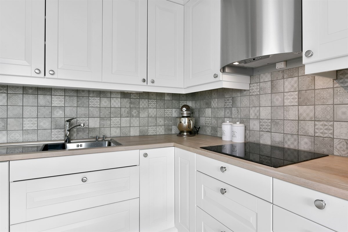 Over benken er det montert fliser og belysning, og over kokesonen er det montert ventilator. Galleribilde