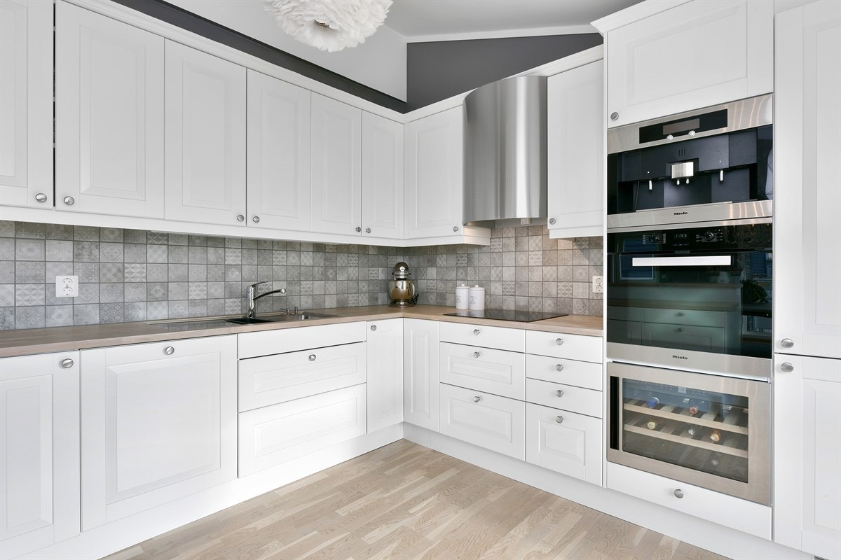 Kjøkkeninnredningen har lyse, profilerte fronter og en heltre benkeplate med underlimt oppvaskkum. Galleribilde