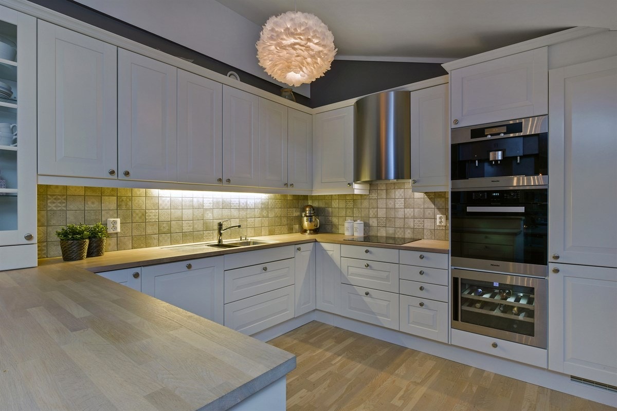 Kjøkkeninnredningen har lyse, profilerte fronter og en heltre benkeplate med underlimt oppvaskkum. Galleribilde