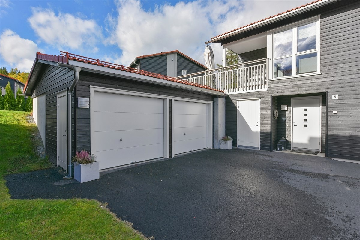 Det er parkering i dobbeltgarasje med elektriske porter. Galleribilde
