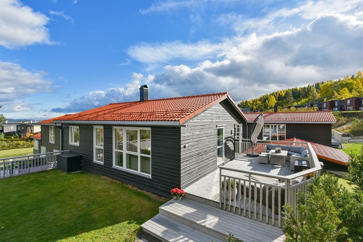 Fra terrassen er det et par trinn ned til en flott, steinbelagt platting og hage. Galleribilde