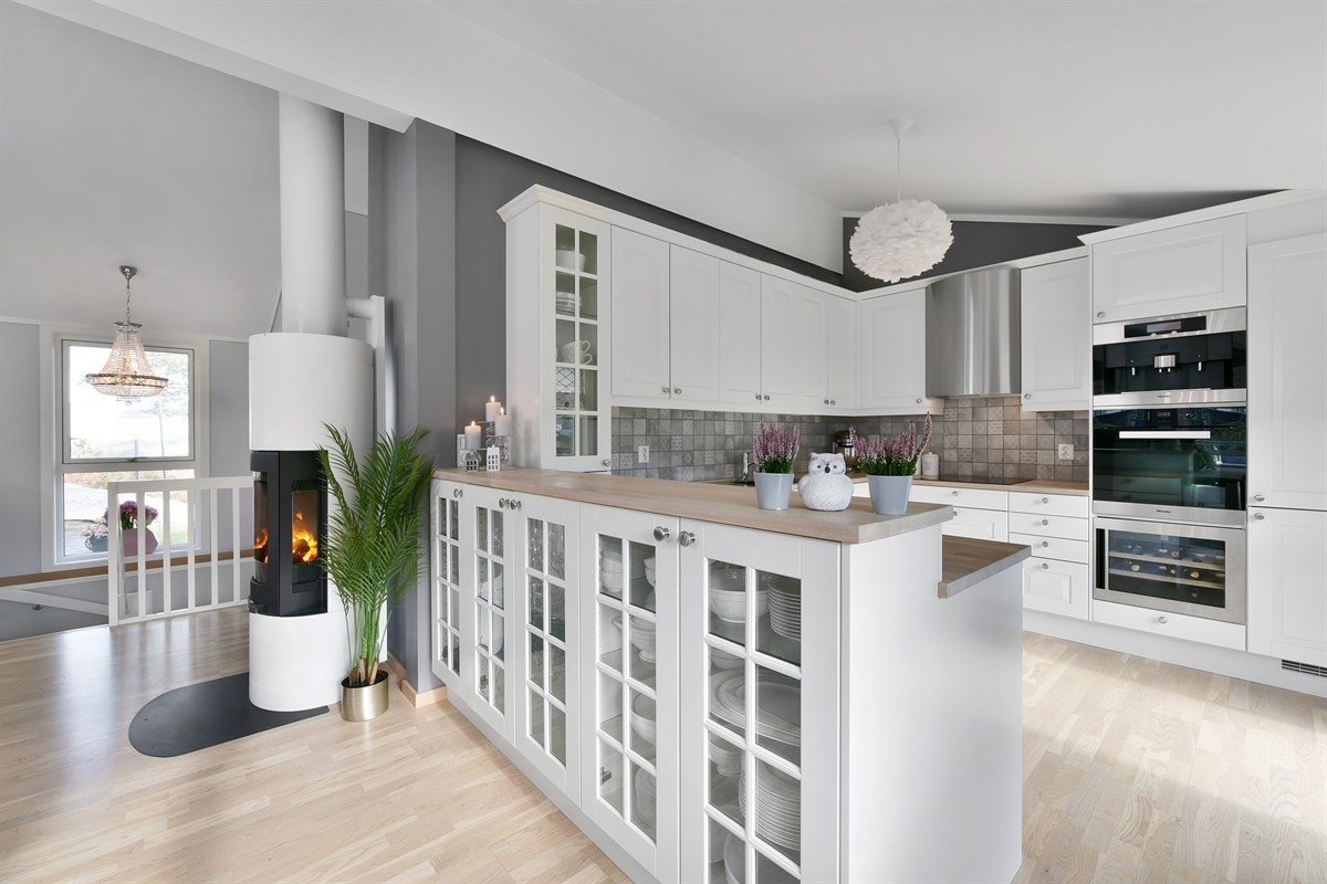 Stuen og kjøkkenet er praktisk adskilt av en lekker barløsning med vitrineskap. Galleribilde