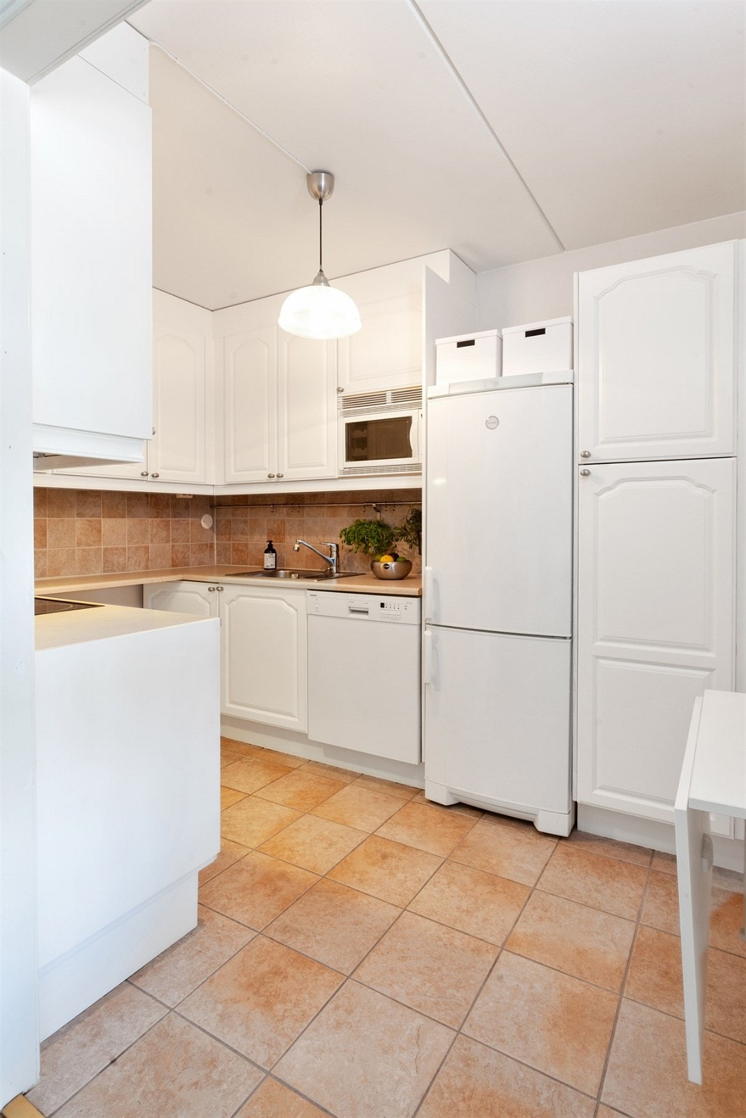 Kjøkkenet har fliser på gulv med varmekabler Galleribilde