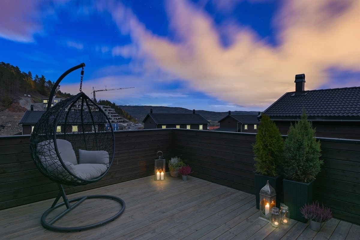 Terrassen har tremmegulv, tett brunbeiset rekkverk, levegg mot gårdsplass, samt god plass for utemøblement. Galleribilde