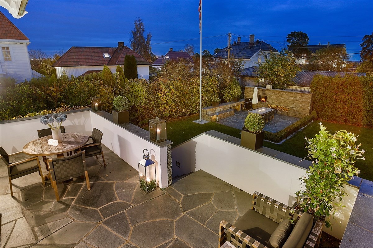 Fra hagen går det trapp opp til en trivelig terrasse som er tilknyttet kjøkkenet via skyvedør. Terrassen er ca. 21 kvm og har skiferdekke med rom for sittegruppe. Både terrassen og hagen har sydvendt orientering med gode solforhold. Galleribilde