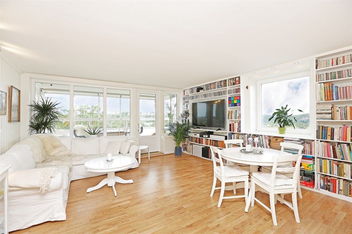 Romslig stue med plass til spisebord. Innredet med stor bokhylle Galleribilde